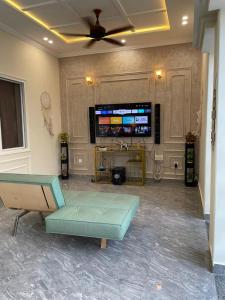 a living room with a couch and a flat screen tv at ASNB Farm House 2BHK with Pool in Multan