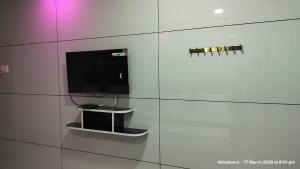 a white wall with a tv on a wall at Hotel Grand Arputha in Velankanni