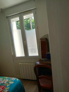 a room with two windows and a desk and a bed at FamousHouse in Le Havre