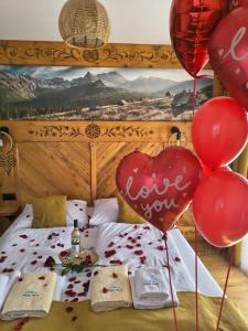 a bed with red balloons and a heart with the words love you at Cicha Woda 300 m od Gorący Potok i Termy Szaflary in Szaflary