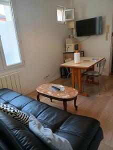 a living room with a couch and a table at FamousHouse in Le Havre