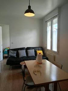 a living room with a black couch and a table at FamousHouse in Le Havre