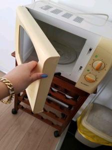 a person holding the door of a microwave at FamousHouse in Le Havre +2 photos