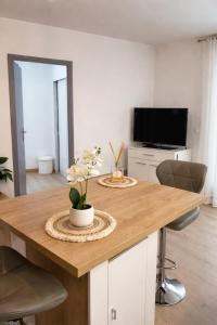a kitchen with a wooden table with a television and a dining room at Appartement charmant au cœur de Saint-Rémy, idéal pour une escapade provençale ! in Saint-Rémy-de-Provence