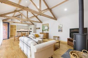 a living room with a white couch and a tv at The Saddlery in Norwich