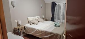 a bedroom with a bed with white sheets and pillows at Les 4 nuances in Youx