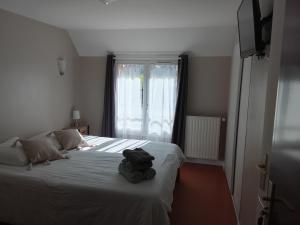 a stuffed animal sitting on a bed in a bedroom at Les 4 nuances in Youx