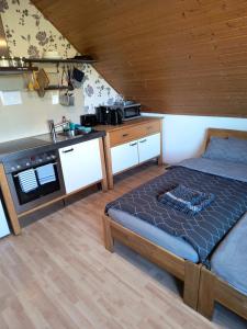 a bedroom with a large bed and a kitchen at Auerandstudio in Nienhagen