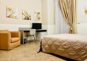 a bedroom with a bed and a desk and a chair at Grand Hotel Stella Maris Italia in Palmi
