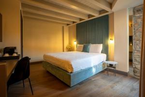 a hotel room with a bed and a table and a chair at Relais Villa Borghetto - Adults only in Valeggio sul Mincio +80 photos