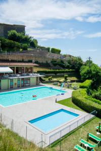 a large swimming pool in a resort with chairs at Appartamenti Bonaventura in Tignale