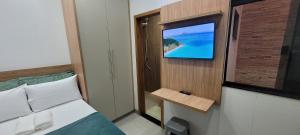 a room with a bed and a tv on a wall at Residencial Hanna in Anápolis