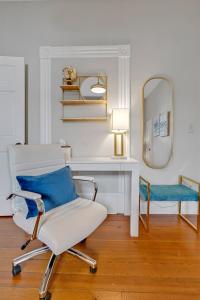 a room with a chair and a desk and a mirror at Savannah Suite on Front in Wilmington