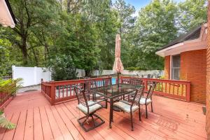a patio with a table and chairs on a wooden deck at Market District Pool House in Statesboro