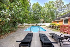 a swimming pool with two lounge chairs and a swimming pool at Market District Pool House in Statesboro