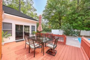 a patio with a table and chairs on a deck at Market District Pool House in Statesboro