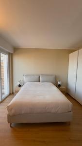 a bedroom with a white bed with two night stands at NB Luxury Attico Vista Mare in Sanremo