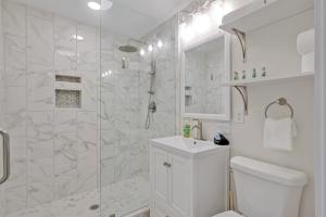 a white bathroom with a shower and a toilet at Downtown Bliss in Wilmington
