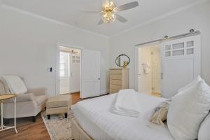 a white bedroom with a bed and a chair at Downtown Bliss in Wilmington +19 photos