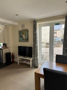 a living room with a flat screen tv and a table at Trotters Place - Bradwell in Bradwell