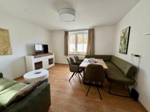 a living room with a couch and a table at Komfortables Innenstadt-Apartment WOLF - Zentrumlage in Sankt Pölten