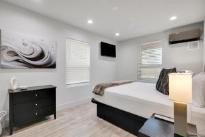 a bedroom with white walls and a bed and a desk at The Pearl Stylish Couples Getaway in Wilmington