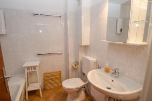 un bagno bianco con un water e un lavandino di Appartement THE GOOD VIEW by All in One Apartments a Zell am See Altre 37 foto