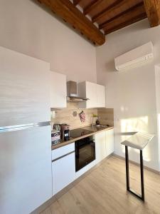 a kitchen with white cabinets and a table and a refrigerator at Agriturismo Colle Sereno in Castiglione dʼOrcia