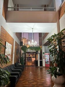 a lobby with black leather chairs and a chandelier at Ancona Center Hotel in Amparo