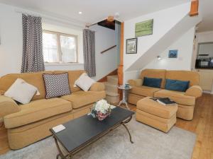a living room with two couches and a table at Happy Landing in Harlech