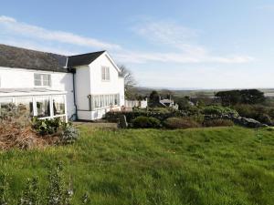 a white house with a green field in front of it at Happy Landing in Harlech