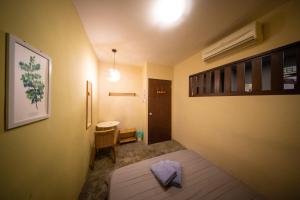 a room with a bed and a table and a chair at The Cottage Stay - self check-in in Kuching +40 photos
