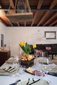 a table with wine glasses and a box of cheese at Casa di Cocco in Alzano Lombardo