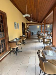 a restaurant with tables and chairs in a room at Pousada Paisagem in Paraty