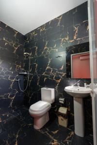 a bathroom with a toilet and a sink at Hotel Bicaj in Shkodër