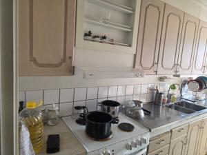 a kitchen with a stove with pots and pans on it at Ett mysigt appartement in Linköping