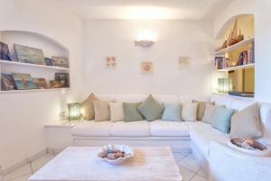a living room with a white couch and a table at Costa Corallina Villa with direct beach access and stunning views in Costa Corallina
