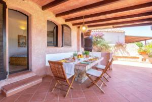 a table and chairs sitting on a patio at Costa Corallina Villa with direct beach access and stunning views in Costa Corallina