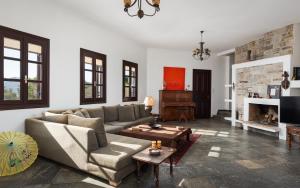 a living room with a couch and a fireplace at My Way Kavos Villa in Agia Marina Aegina +63 photos