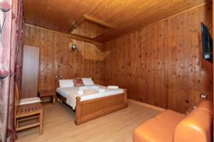 a bedroom with a bed in a wooden room at Hotel Bicaj in Shkodër +6 photos