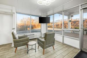 a living room with two chairs and a table and windows at Super 8 by Wyndham Kingsport /I-81 in Kingsport
