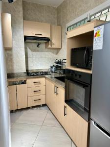 a kitchen with wooden cabinets and a black appliances at Nahé Résidence Deux Plateaux in Abidjan