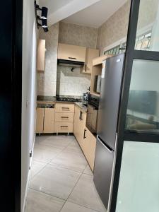 a kitchen with stainless steel appliances and brown cabinets at Nahé Résidence Deux Plateaux in Abidjan +6 photos