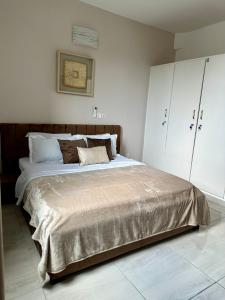 a bedroom with a large bed with white walls at Nahé Résidence Deux Plateaux in Abidjan