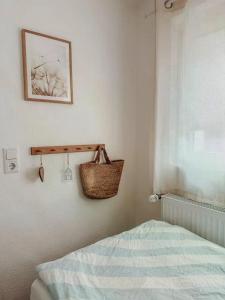 a bedroom with a bed and a basket on the wall at Ferienhaus "Schmale Gisela" bis zu 6 Personen mit Garten und Parkplätzen in Seligenstadt