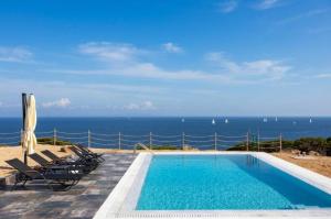 a swimming pool with a view of the ocean at My Way Kavos Villa in Agia Marina Aegina