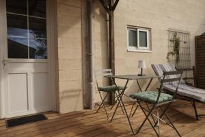 a patio with a table and chairs and a door at Maison individuelle in Triac-Lautrait