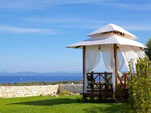 a gazebo with chairs under a white umbrella at Villa Carla in Bonifacio