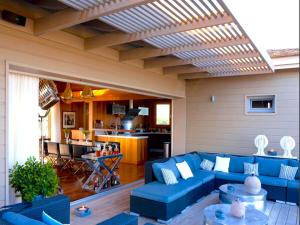 a living room with blue couches and a kitchen at Villa Carla in Bonifacio