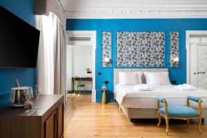 a bedroom with blue walls and a bed with blue accents at Água Hotels Lagos Bay in Lagos